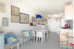 a dining room with a white table and blue chairs at Fronte mare con parcheggio! in Grado