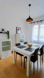 a dining room with a white table and chairs at El balcón de Mafalda in Villarcayo