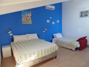 a bedroom with two beds and a blue wall at B&B Oasi al Mare in Agropoli