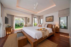 a bedroom with a large bed with a table on it at Grand garden villa Free Airport Pickup from 7 days in Phuket +27 photos