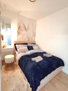 a bedroom with a bed with two towels on it at Enidor Wellness Apartman in Siófok +13 photos