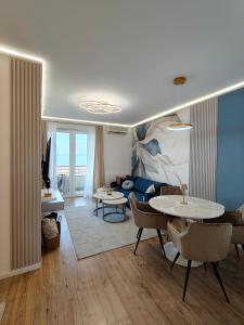 a living room with a table and a couch at Enidor Wellness Apartman in Siófok