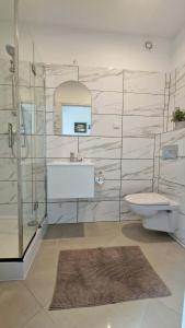 a bathroom with a toilet and a shower and a sink at Bos-Znam Pokoje in Gdynia