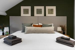 a bedroom with a white bed with towels on it at The Courtyard in Exeter