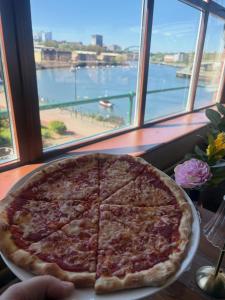 a large pizza sitting on a table in front of a window at Boars Head Boutique Hotel in Sunderland