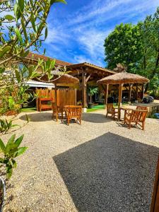 a patio with chairs and umbrellas and a table at La biche au bois piscine chauffee jacuzzi in Cazals