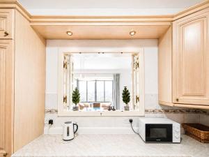 a kitchen with a microwave and a window at The Horizon - Sea View 8 in Sliema