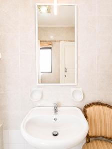 a bathroom with a sink and a mirror and a chair at The Horizon - Sea View 8 in Sliema +32 photos