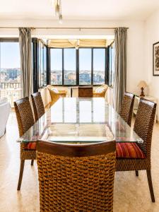 a dining room with a glass table and chairs at The Horizon - Sea View 8 in Sliema
