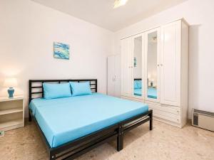 a bedroom with a blue bed and a cabinet at The Horizon - Sea View 8 in Sliema