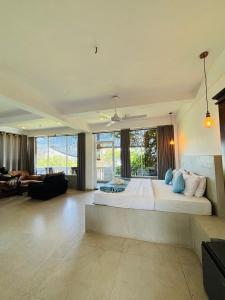 a large bedroom with a large bed and a living room at Cozy Cocos Midigama in Ahangama