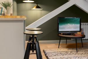 a living room with a tv and a table with a stool at The Courtyard in Exeter