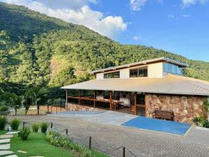 a house with a mountain in the background at Sítio Morro do Balaio in Guarapari