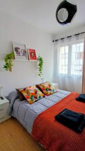 a bedroom with a large bed with colorful pillows at El balcón de Mafalda in Villarcayo