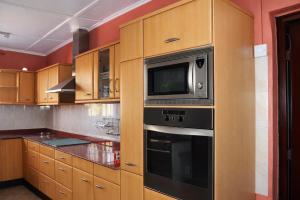 a kitchen with a microwave and a stove at Rico Home Stay in Nkotunsi