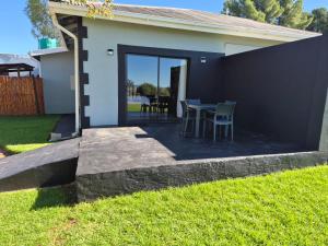 a patio with a table and chairs in a yard at Toekoms Inn in Aliwal North
