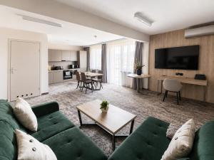 a living room with a green couch and a table at Hotel Pod Jedlami in Wisła