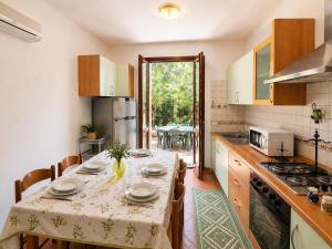 a kitchen with a table with a table cloth on it at Villa Pinta - Key to Villas in Codaruina