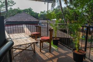 two chairs and a bench on a balcony with plants at TriboRoots Hostel in Anjuna