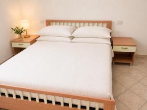 a bedroom with a large bed with white sheets and pillows at Villa Pinta - Key to Villas in Codaruina +5 photos