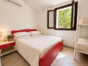 a small bedroom with a bed and a window at Villa Pinta - Key to Villas in Codaruina
