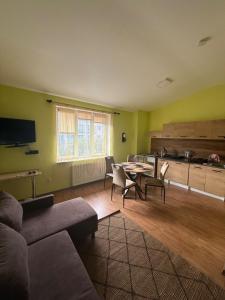 a living room with a couch and a table and a kitchen at Hotel Grodzki in Sandomierz