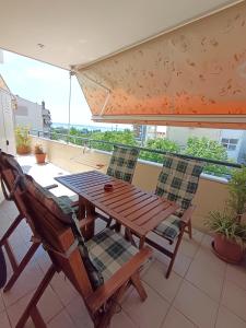 a wooden table and chairs on a balcony at Blue Horizon SKG in Thessaloniki