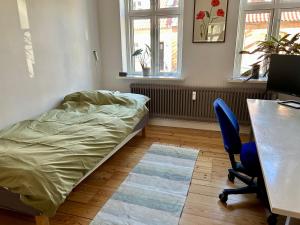 a bedroom with a bed and a desk and a chair at Ole Rømers Gade 108 in Aarhus