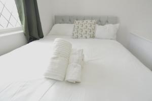 a white bed with two white pillows on it at The Linwood Terrace in Eastwood