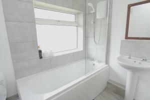 a bathroom with a tub and a sink and a window at The Linwood Terrace in Eastwood +46 photos