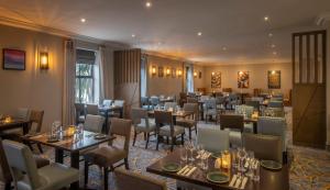 a restaurant with tables and chairs in a room at Maldron Hotel & Leisure Centre, Oranmore Galway in Oranmore