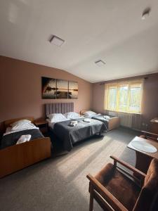 a bedroom with two beds and a couch at Hotel Grodzki in Sandomierz