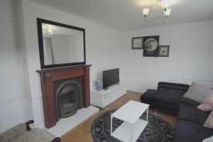 a living room with a couch and a mirror at The Linwood Terrace in Eastwood
