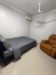 a bedroom with a bed and a chair at Doctors Apartment in Suva