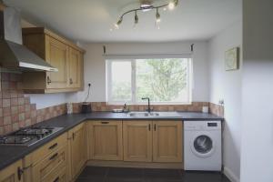 a kitchen with a sink and a washing machine at The Linwood Terrace in Eastwood