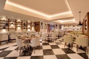 a restaurant with tables and chairs on a checkered floor at Lemon Tree Premier, Biratnagar, Nepal in Biratnagar