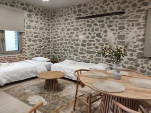 a room with two beds and a table and chairs at Meteora Kalimera 1 in Kalabaka