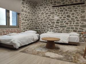 a room with two beds and a table in it at Meteora Kalimera 1 in Kalabaka +12 photos