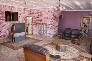 a living room with a pink stone wall at Rico Home Stay in Nkotunsi