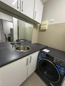 a kitchen with a sink and a washing machine at Doctors Apartment in Suva