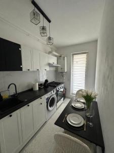 a kitchen with a table with plates on it at Noblesse residence - parking Militari residence Chiajna Dudu in Chiajna