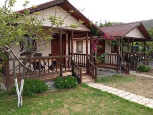 a house with a wooden deck and a porch at Fesleğenbükü Kamp in Çökertme +13 photos