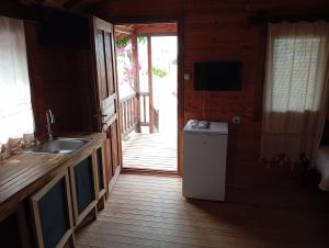 a kitchen with a sink and a door to a porch at Fesleğenbükü Kamp in Çökertme