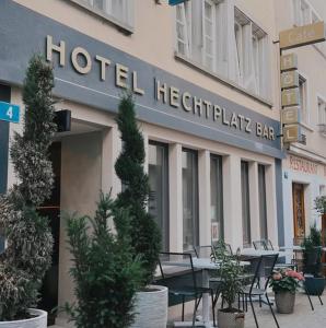 a hotel headquarters with tables and plants in front of it at Hotel Hechtplatz Self Check In in Zurich