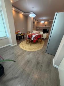 a living room with a table and a dining room at Valentina Cozy 2-Bedroom House in Lushnjë