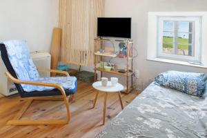 a living room with a chair and a table at Chambres en Charente Maritime in Loiré-sur-Nie