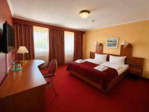 ein Hotelzimmer mit Bett und Schreibtisch in der Unterkunft Hotel Schwarzenbek in Schwarzenbek