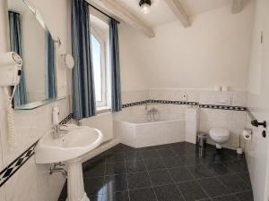 ein Badezimmer mit Waschbecken, Badewanne und Toilette in der Unterkunft Hotel Schwarzenbek in Schwarzenbek + 8 Fotos