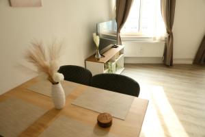 a dining room with a table with a vase on it at Olive Residence Lübeck in Lübeck