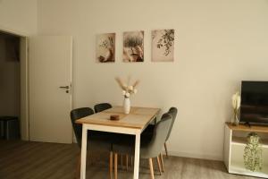 a dining room with a wooden table and chairs at Olive Residence Lübeck in Lübeck